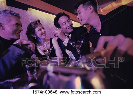 Three mid adult men and a mid adult woman sitting in a bar View Large Photo Image Stock Photo - Three mid adult men and a mid adult woman sitting in a bar. Fotosearch