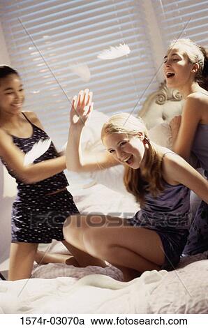 Three teenage girls having a pillow fight View Large Photo Image Stock Image - Three teenage girls having a pillow fight. Fotosearch