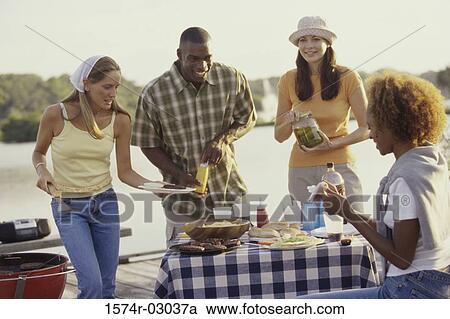 Three young women and a young man at an outdoor picnic together View Large Photo Image Stock Image - Three young women and a young man at an outdoor picnic together. Fotosearch