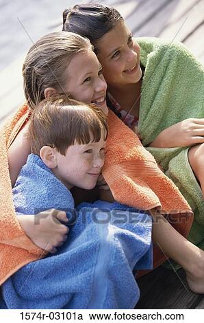 Two girls and a boy wrapped in towels sitting on a dock View Large Photo Image Stock Image - Two girls and a boy wrapped in towels sitting on a dock. Fotosearch