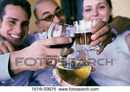 Two young men and a young woman toasting with wineglasses in a restaurant View Large Photo Image Stock Photography - Two young men and a young woman toasting with wineglasses in a restaurant. Fotosearch