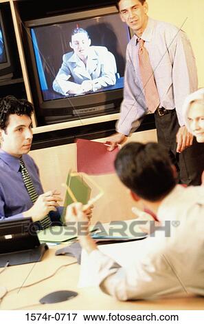 Stock Photo - Business executives at a video conference in an office. Fotosearch