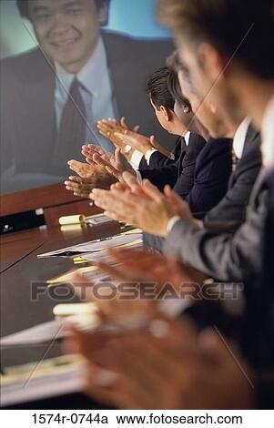 Stock Image - Business executives clapping in an office. Fotosearch