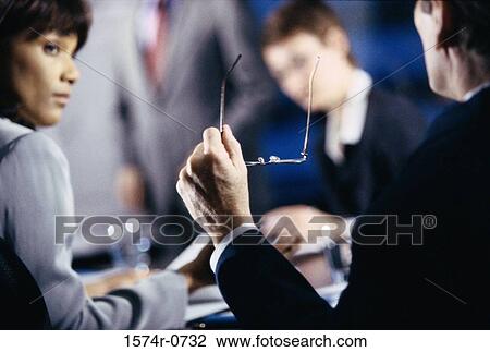 Stock Image - Business executives discussing in an office. Fotosearch