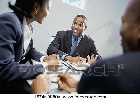 Stock Image - Business executives discussing in an office. Fotosearch