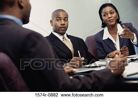 Stock Image - Business executives discussing in an office. Fotosearch