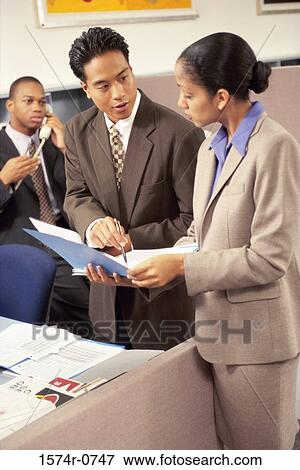 Stock Photo - Business executives discussing in an office. Fotosearch