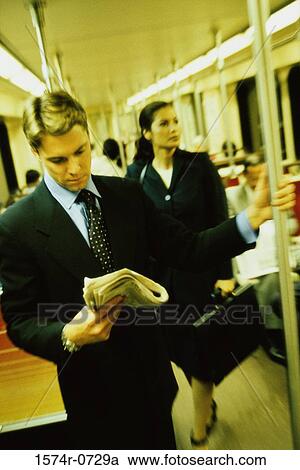 Businessman and a businesswoman standing on a train View Large Photo Image Stock Image - Businessman and a businesswoman standing on a train. Fotosearch