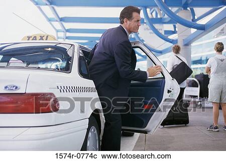 Businessman getting out of a taxi View Large Photo Image Stock Image - Businessman getting out of a taxi. Fotosearch