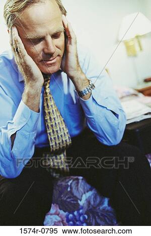 Businessman holding the sides of his head View Large Photo Image Stock Photography - Businessman holding the sides of his head. Fotosearch