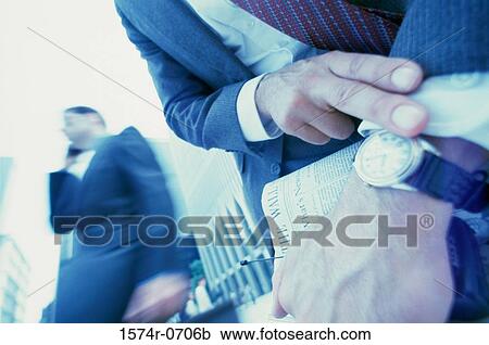 Businessman looking at his wristwatch View Large Photo Image Stock Image - Businessman looking at his wristwatch. Fotosearch