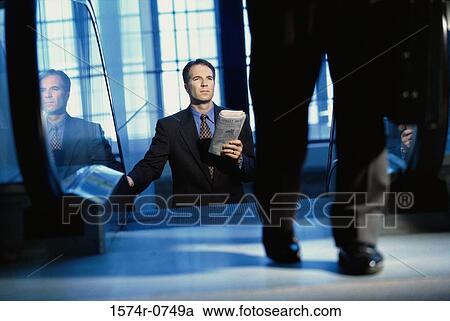 Businessman on an escalator View Large Photo Image Stock Image - Businessman on an escalator. Fotosearch