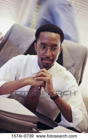 Businessman sitting with his hands together View Large Photo Image Stock Photo - Businessman sitting with his hands together. Fotosearch