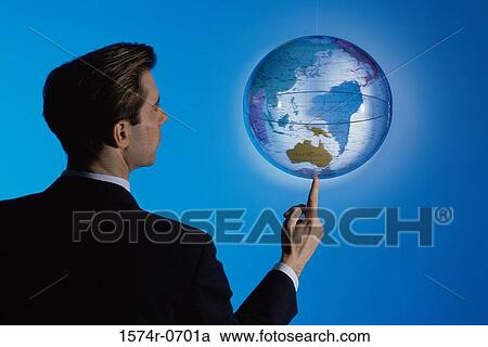 Stock Image - Businessman spinning a globe on his finger. Fotosearch