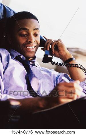 Businessman talking on a telephone View Large Photo Image Stock Photograph - Businessman talking on a telephone. Fotosearch