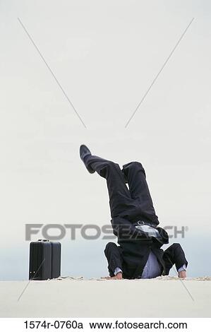 Stock Image - Businessman with his head in the sand. Fotosearch