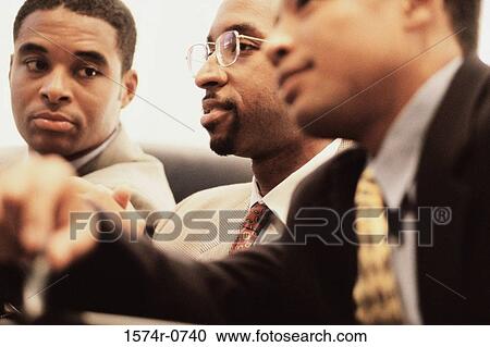 Stock Image - Businessmen in a meeting. Fotosearch