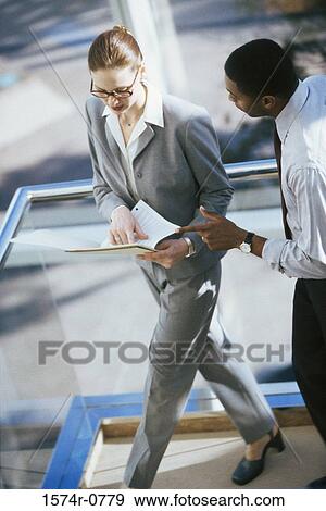 Stock Photo - Businesswoman and a businessman discussing in an office. Fotosearch