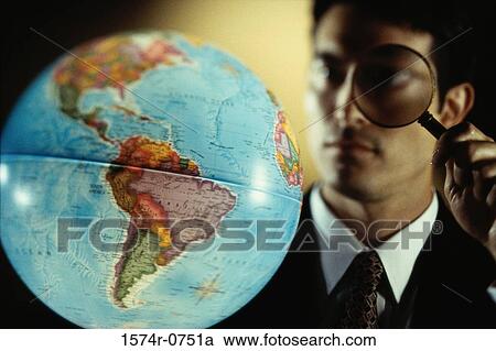 Close-up of a businessman looking through a magnifying glass at a globe View Large Photo Image Stock Image - Close-up of a businessman looking through a magnifying glass at a globe. Fotosearch