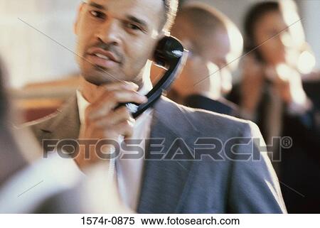 Stock Photography - Close-up of a businessman talking on a landline telephone. Fotosearch