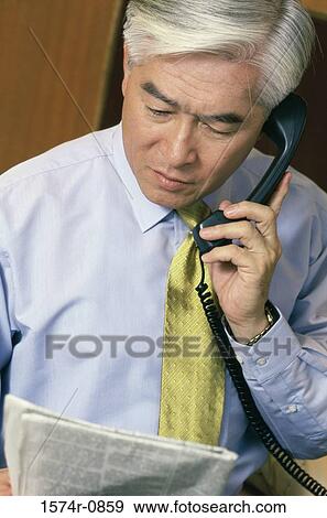 Stock Photo - Close-up of a businessman talking on the landline telephone. Fotosearch