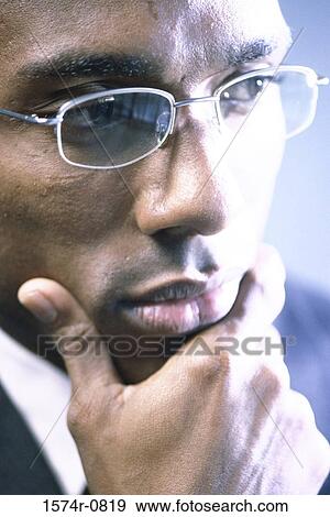 Stock Photo - Close-up of a businessman with his hand on his chin. Fotosearch
