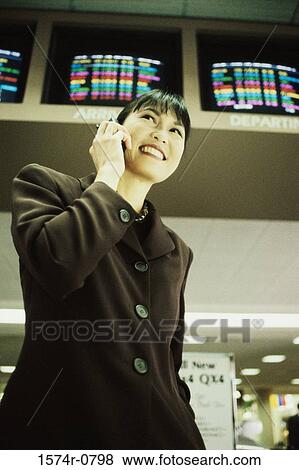 Stock Photo - Low angle view of a businesswoman talking on a mobile phone. Fotosearch