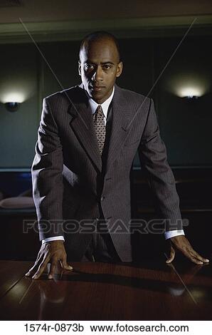 Stock Image - Portrait of a young businessman standing in his office. Fotosearch
