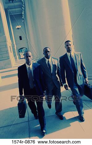 Portrait of three businessmen walking together View Large Photo Image Stock Photograph - Portrait of three businessmen walking together. Fotosearch