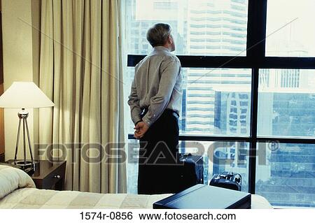 Stock Photograph - Rear view of a businessman looking out a window. Fotosearch