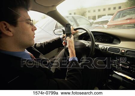 Side profile of a businessman dialing a mobile phone while in a car View Large Photo Image Stock Image - Side profile of a businessman dialing a mobile phone while in a car. Fotosearch