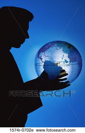 Stock Image - Silhouette of a businessman holding a globe. Fotosearch