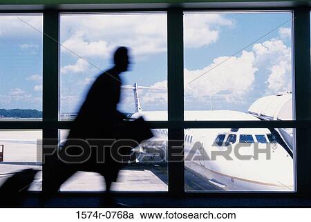 Stock Image - Silhouette of a businessman running at an airport. Fotosearch