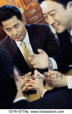Stock Image - Three businessmen discussing. Fotosearch