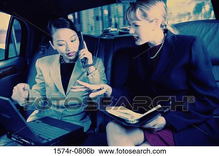 Two businesswomen discussing in a car View Large Photo Image Stock Image - Two businesswomen discussing in a car. Fotosearch