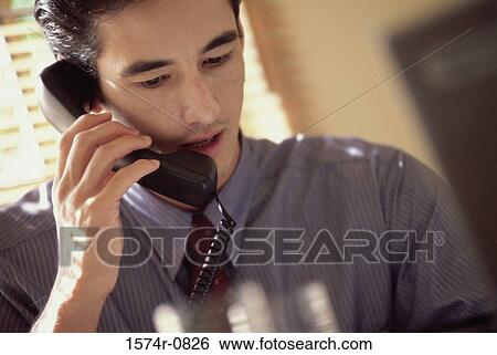 Young businessman talking on the telephone View Large Photo Image Stock Photograph - Young businessman talking on the telephone. Fotosearch