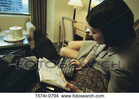 Young Businesswoman lying on a bed using a laptop View Large Photo Image Picture - Young Businesswoman lying on a bed using a laptop. Fotosearch