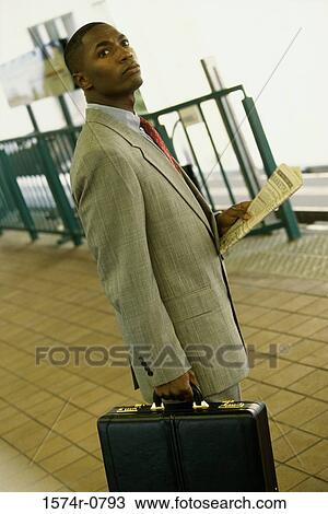 Stock Image - Young man standing with a briefcase. Fotosearch