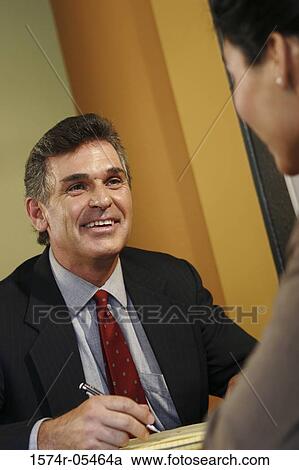 Businessman and a businesswoman talking in an office View Large Photo Image Stock Image - Businessman and a businesswoman talking in an office. Fotosearch