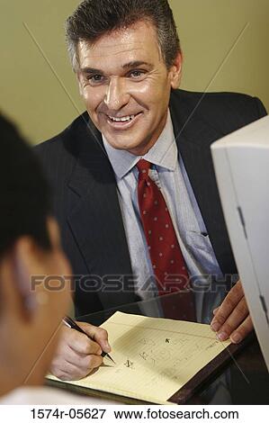 Businessman and a businesswoman talking in an office View Large Photo Image Stock Photo - Businessman and a businesswoman talking in an office. Fotosearch