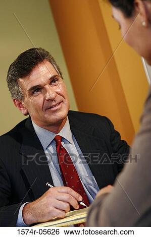 Businessman and a businesswoman talking in an office View Large Photo Image Stock Photograph - Businessman and a businesswoman talking in an office. Fotosearch