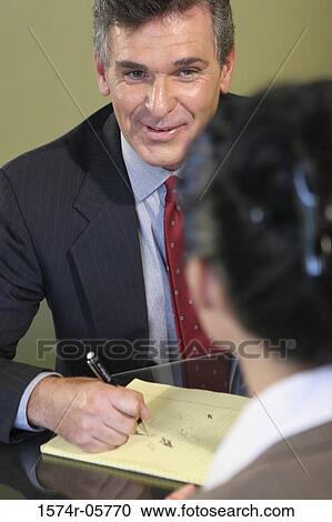 Businessman looking at a businesswoman in an office View Large Photo Image Stock Image - Businessman looking at a businesswoman in an office. Fotosearch