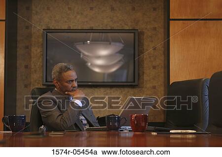 Businessman sitting in a conference room View Large Photo Image Stock Image - Businessman sitting in a conference room. Fotosearch