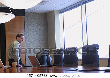 Businessman sitting in a conference room View Large Photo Image Stock Photo - Businessman sitting in a conference room. Fotosearch