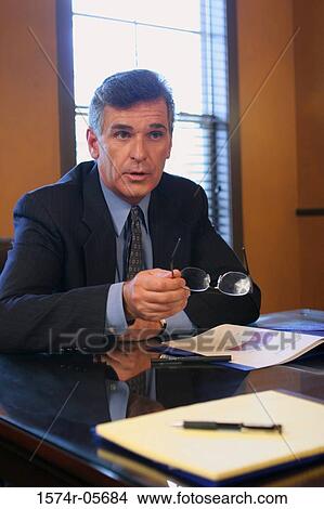 Businessman sitting in an office View Large Photo Image Picture - Businessman sitting in an office. Fotosearch
