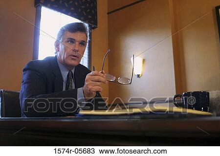 Stock Image - Businessman sitting in an office. Fotosearch