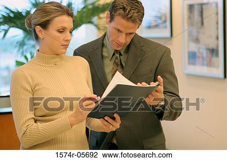 Stock Image - Businessman talking to a businesswoman. Fotosearch