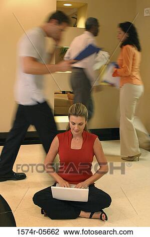 Businesswoman sitting on the floor working on a laptop View Large Photo Image Stock Image - Businesswoman sitting on the floor working on a laptop. Fotosearch