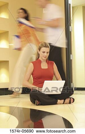 Businesswoman sitting on the floor working on a laptop View Large Photo Image Stock Image - Businesswoman sitting on the floor working on a laptop. Fotosearch