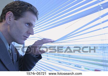 Close-up of a businessman looking through a window View Large Photo Image Stock Image - Close-up of a businessman looking through a window. Fotosearch